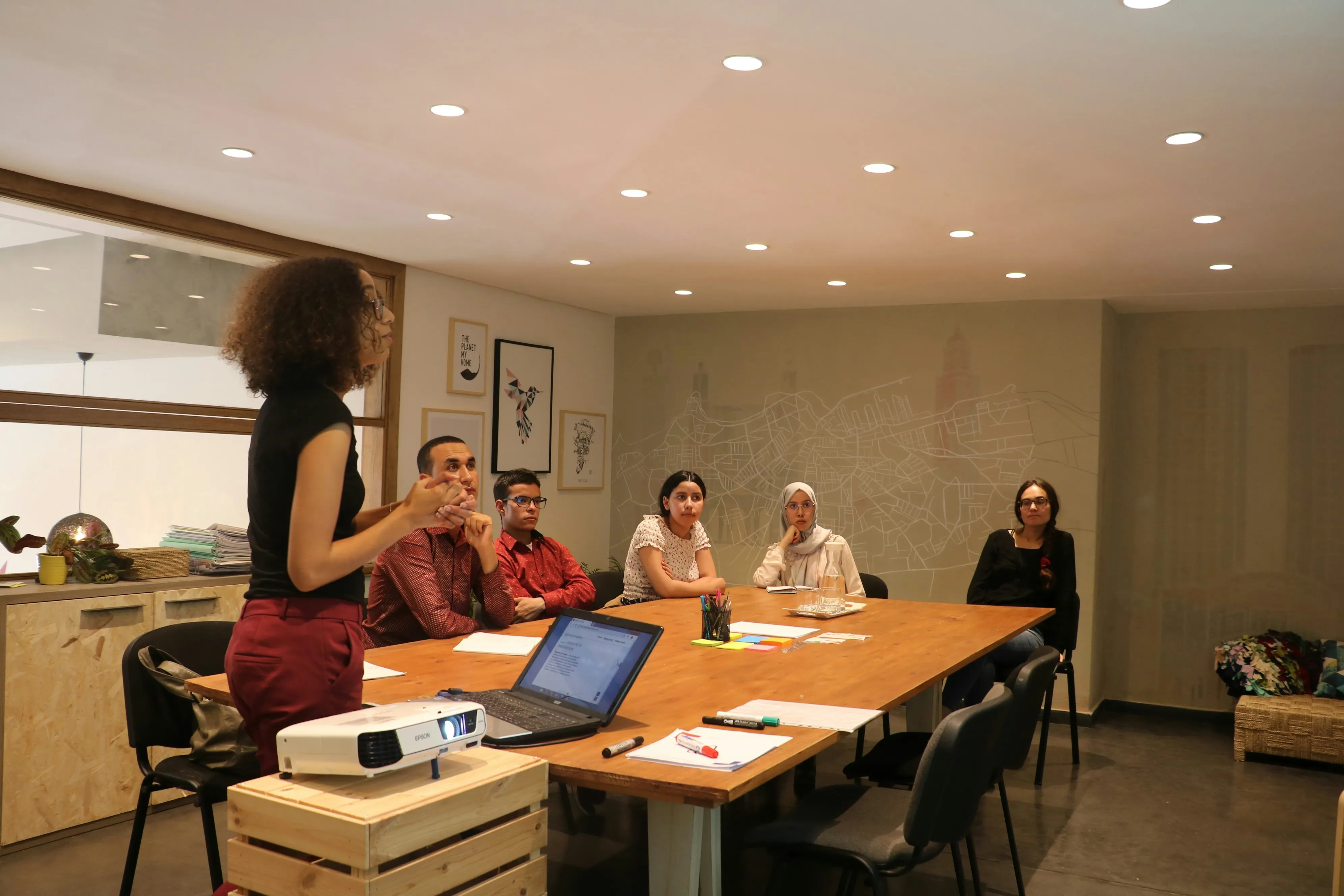 A facilitator standing during a team meeting in a workplace setting
