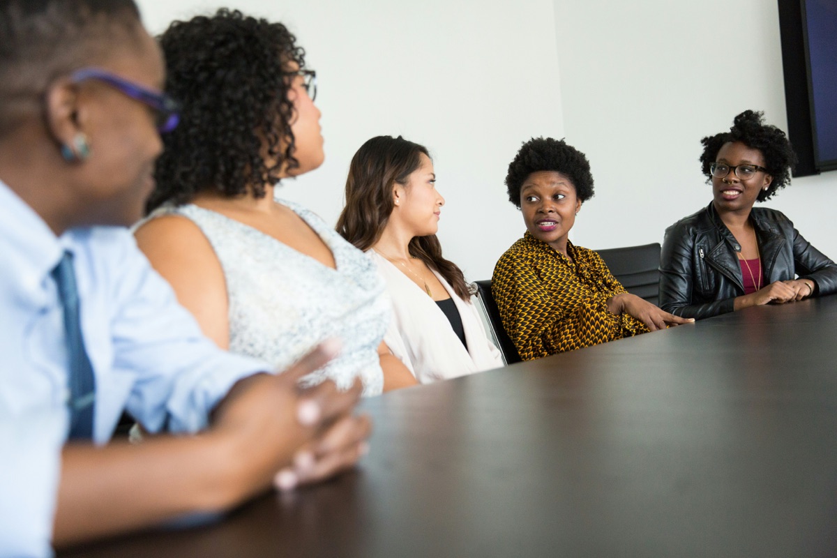 Un groupe de femmes en réunion au travail, concevant ensemble une stratégie