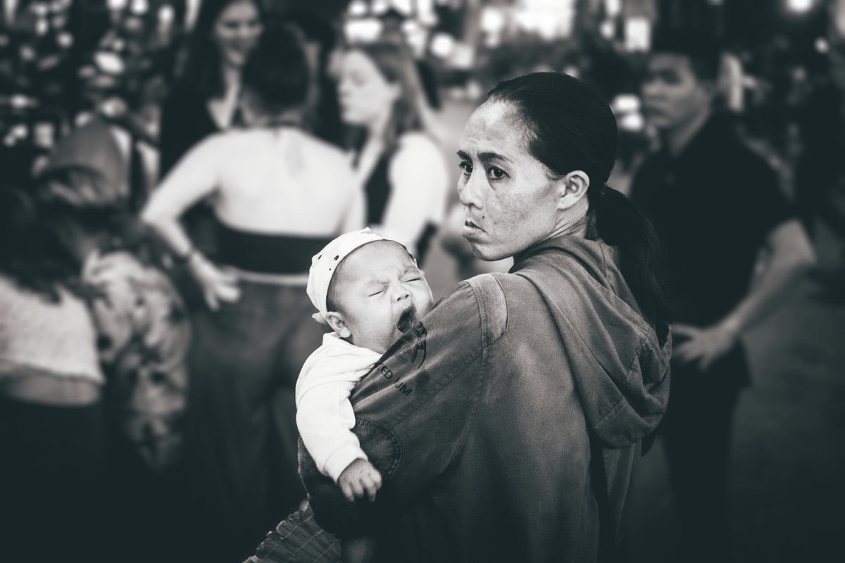 A mother holding her infant close, a portrait of maternal strength