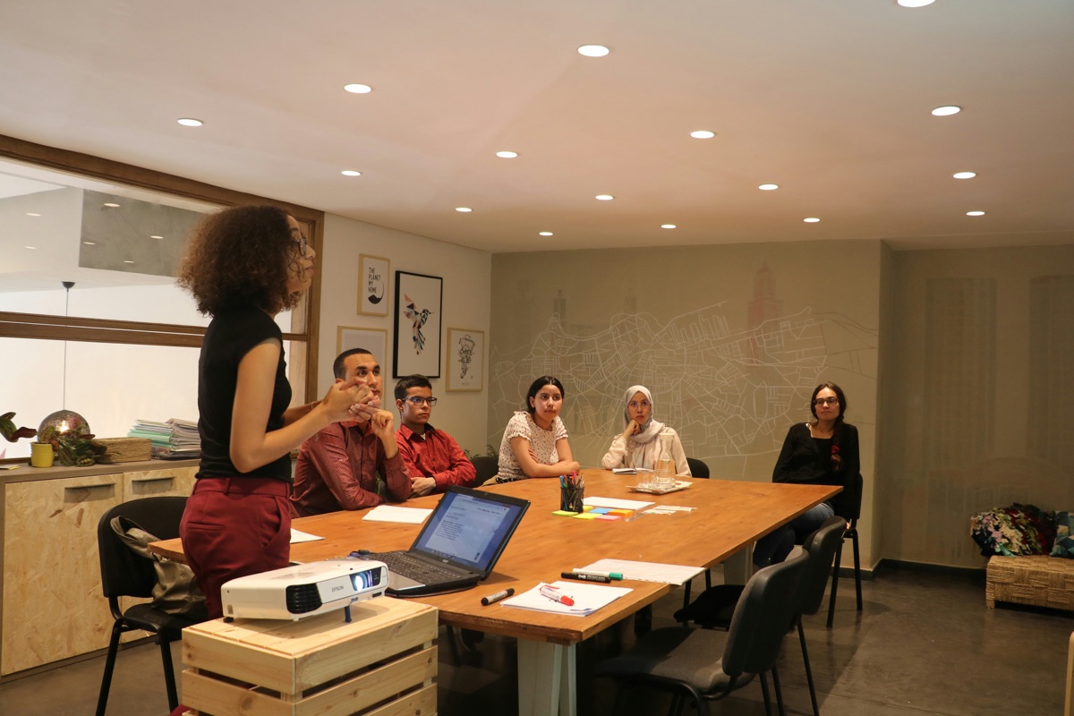 Group in peer counselor training session with projector and notes